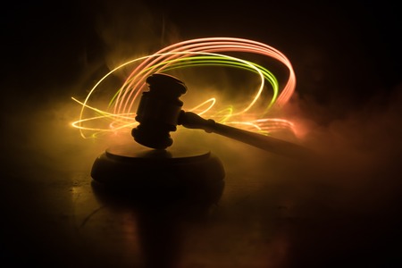 Law theme, mallet of the judge on wooden desk with Lady Justice Statue. Law gavel on dark foggy background with light. Selective focusの写真素材