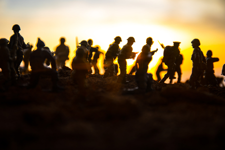 Battle scene. Military silhouettes fighting scene on war fog sky background. World War Soldiers Silhouettes Below Cloudy Skyline At sunset. Artwork Decoration. Selective focusの写真素材