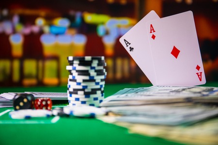 Cards and chips on green felt casino table. Abstract background with copy space. Gambling, poker,...