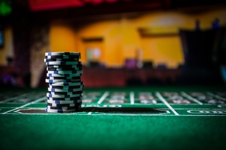 Cards and chips on green felt casino table. Abstract background with copy space. Gambling, poker, casino and cards games theme. Casino elements on green. Selective focusの写真素材