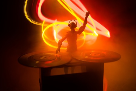 Dj club concept. DJ mixing, and Scratching in a Night Club. Man silhouette on vinyl turntable,...