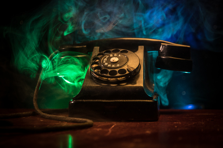 old black telephone on old wood plank with art dark background with fog and toned light. empty space. Selective focusの写真素材