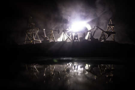 Artwork decoration. Oil pumps and oil rigs energy industrial machines for petroleum at night with fog and backlight. Energy industrial concept. Selective focusの写真素材