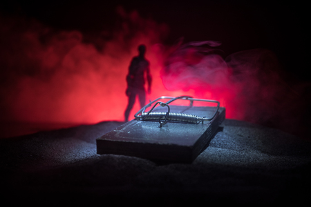 Creative concept. Artwork decoration of mousetrap in sand on dark toned foggy background. Mousetrap...