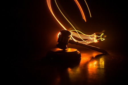 Law theme, mallet of the judge on wooden desk with Lady Justice Statue. Law gavel on dark foggy background with light. Selective focusの写真素材
