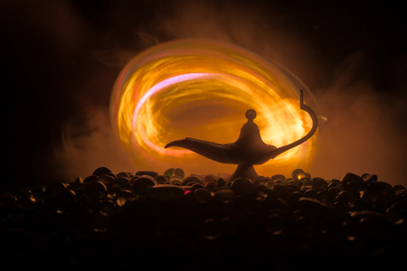 Antique Aladdin arabian nights genie style oil lamp with soft light white smoke, Dark background. Lamp of wishes conceptの写真素材