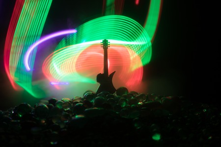Music concept. Acoustic guitar on a dark background under beam of light with smoke. Emptry space for...