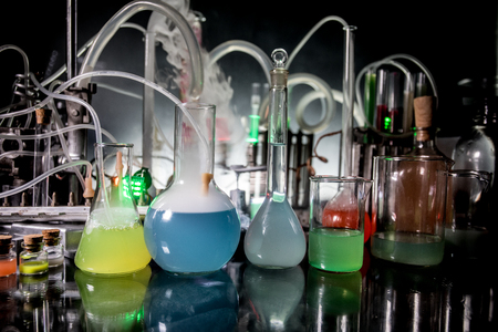 Pharmacy and chemistry theme. Test glass flask with solution in research laboratory. Science and medical background. Laboratory test tubes on dark toned background , science research equipment conceptの写真素材