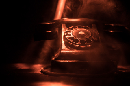 old black telephone on old wood plank with art dark background with fog and toned light. empty space. Selective focusの写真素材