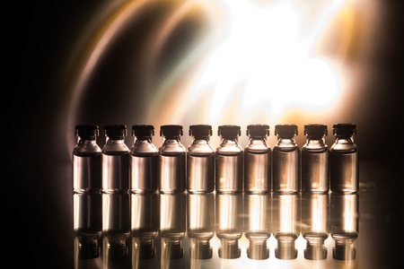 Pharmacy and chemistry theme. Test glass flask with solution in research laboratory. Science and medical background. Laboratory test tubes on dark toned background , science research equipment conceptの写真素材