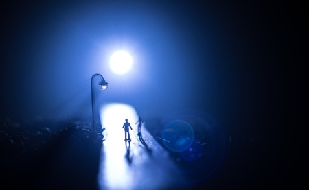 Artwork decoration. Silhouette of couple walking under street lights in night. Peaceful atmosphere in mist. Foggy air. Love concept. Selective focusの写真素材