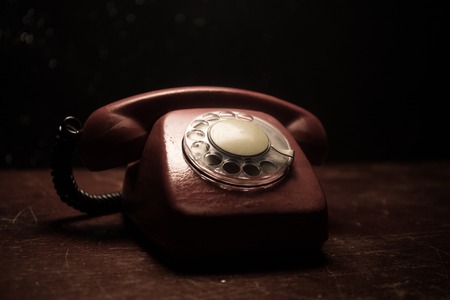 old black telephone on old wood plank with art dark background with fog and toned light. empty space. Selective focusの写真素材