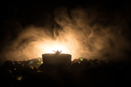 Antique Aladdin arabian nights genie style oil lamp with soft light white smoke, Dark background. Lamp of wishes conceptの写真素材
