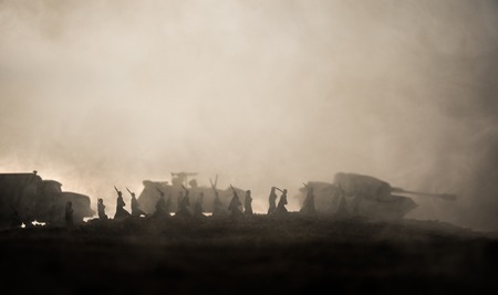 War Concept. Military silhouettes fighting scene on war fog sky background, World War Soldiers Silhouettes below Cloudy Skyline at sunset. Attack scene. Armored vehicles. tank in actionの写真素材