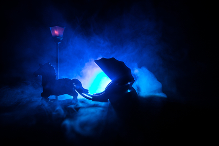 Artwork decoration. Silhouette of old coach with horse on dark toned foggy background. Selective focusの写真素材