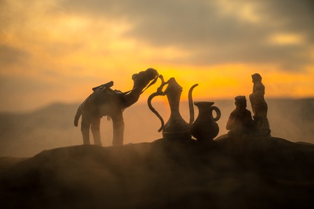 Camel caravan going through the sand dunes in the desert at sunset. Eastern travel concept. Artwork decorationの写真素材