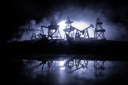 Artwork decoration. Oil pumps and oil rigs energy industrial machines for petroleum at night with fog and backlight. Energy industrial concept. Selective focusの写真素材