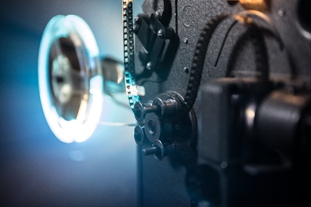 Old vintage movie projector on a dark background with fog and light. Concept of film-making....