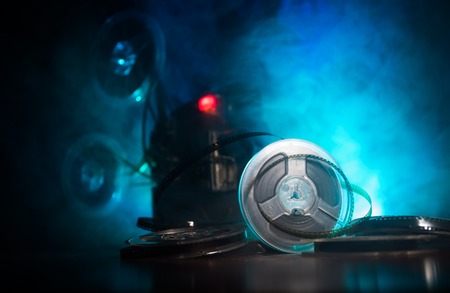 Old vintage movie projector on a dark background with fog and light. Concept of film-making. Selective focusの写真素材