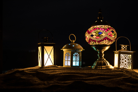 Ornamental Arabic lantern with burning candle glowing at night. Festive greeting card, invitation for Muslim holy month Ramadan Kareem.の写真素材