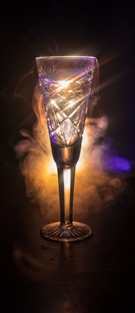 Closeup wine glass with fog at dark background. Beautiful glass with smoke and light. Selective focusの写真素材