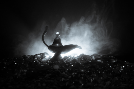 Antique Aladdin arabian nights genie style oil lamp with soft light white smoke, Dark background. Lamp of wishes conceptの写真素材