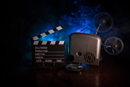 Old vintage movie projector on a dark background with fog and light. Concept of film-making. Selective focusの写真素材