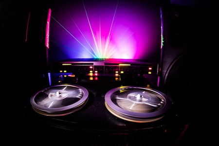 Old vintage reel to reel player and recorder on dark toned foggy background. Analog Stereo Open Reel...
