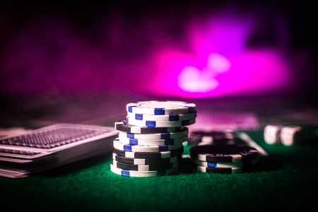 Cards and chips on green felt casino table. Abstract background with copy space. Gambling, poker, casino and cards games theme. Casino elements on green. Selective focusの写真素材