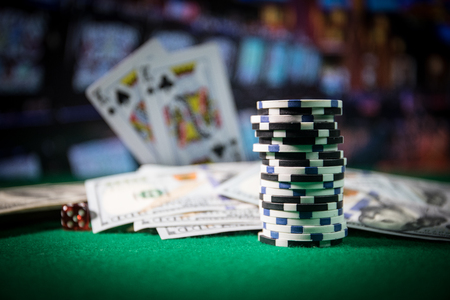 Cards and chips on green felt casino table. Abstract background with copy space. Gambling, poker, casino and cards games theme. Casino elements on green. Selective focusの写真素材