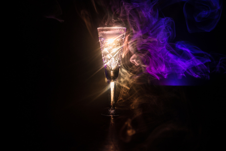 Closeup wine glass with fog at dark background. Beautiful glass with smoke and light. Selective focusの写真素材