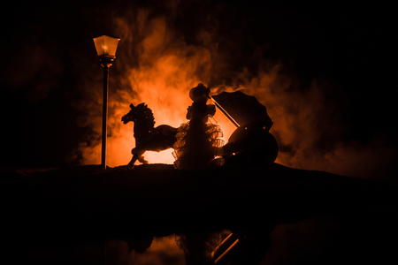 Artwork decoration. Silhouette of old coach with horse on dark toned foggy background. Selective focusの写真素材