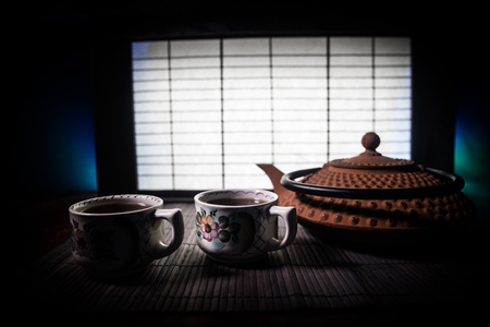 Tea concept. Japanese tea ceremony culture east beverage. Teapot and cups on table with bamboo and tradicional Japan ornament decor elementsの写真素材