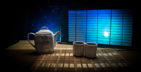 Tea concept. Japanese tea ceremony culture east beverage. Teapot and cups on table with bamboo and tradicional Japan ornament decor elementsの写真素材