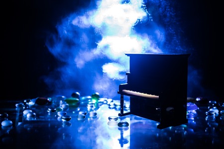 Creative concept. Artwork decoration with piano on dark toned foggy background with light. Selective focusの写真素材
