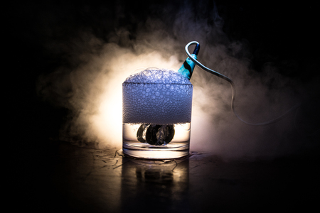 Vintage electric heater for brewing tea in a cup on dark toned foggy background. Heating water in a glass after mustard. The old method of brewing tea.の写真素材