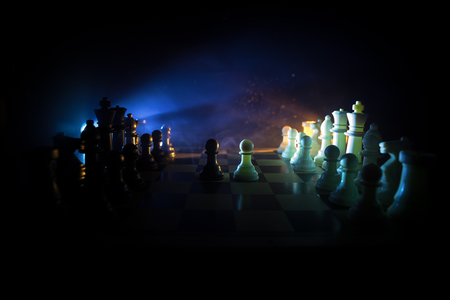 Chess board game concept of business ideas and competition. Chess figures on a dark background with smoke and fog. Selective focusの写真素材