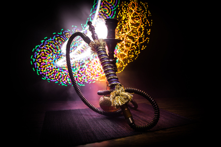 Hookah hot coals on shisha bowl on dark foggy background. Stylish oriental shisha. Creative conceptの写真素材
