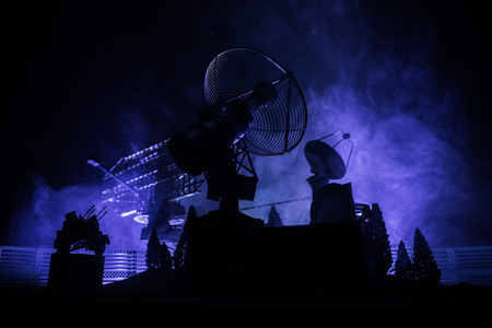Silhouettes of satellite dishes or radio antennas against night sky. Space observatory or Air...