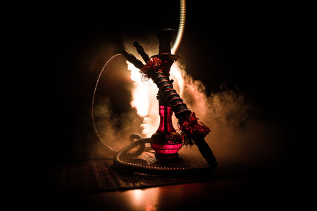 Hookah hot coals on shisha bowl on dark foggy background. Stylish oriental shisha. Creative conceptの写真素材