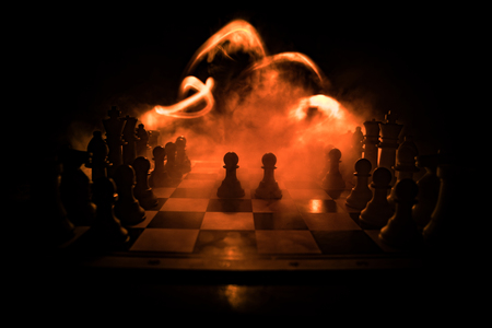 Chess board game concept of business ideas and competition. Chess figures on a dark background with smoke and fog. Selective focusの写真素材