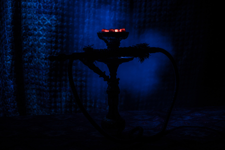 Hookah hot coals on shisha bowl on dark foggy background. Stylish oriental shisha. Creative conceptの写真素材