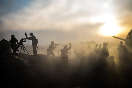 War Concept. Military silhouettes fighting scene on war fog sky background, World War Soldiers Silhouette Below Cloudy Skyline at sunset.の写真素材