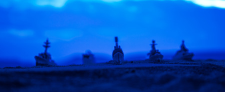 Military navy ships in a sea bay at sunset time. Artwork table decoration. Selective focusの写真素材