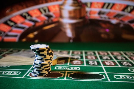Cards and chips on green felt casino table. Abstract background with copy space. Gambling, poker,...