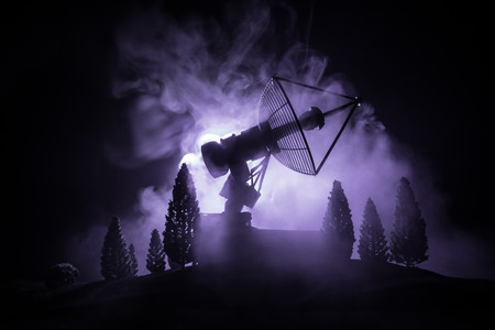 Silhouettes of satellite dishes or radio antennas against night sky. Space observatory or Air defence radar over dramatic night sky. Creative artwork decoration. Selective focusの写真素材