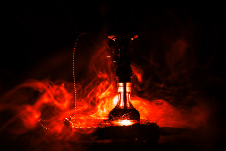 Hookah hot coals on shisha bowl on dark foggy background. Stylish oriental shisha. Creative conceptの写真素材