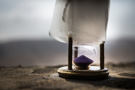 A concept of frozen time. Hourglass in ice. Creative artwork decoration. Selective focus