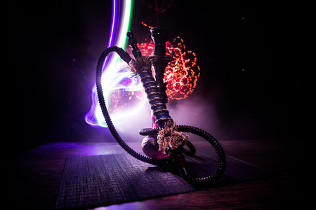 Hookah hot coals on shisha bowl on dark foggy background. Stylish oriental shisha. Creative concept