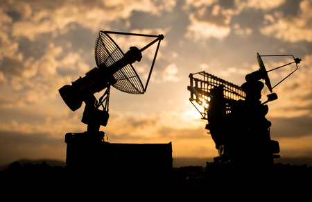 Silhouettes of satellite dishes or radio antennas against night sky. Space observatory or Air...